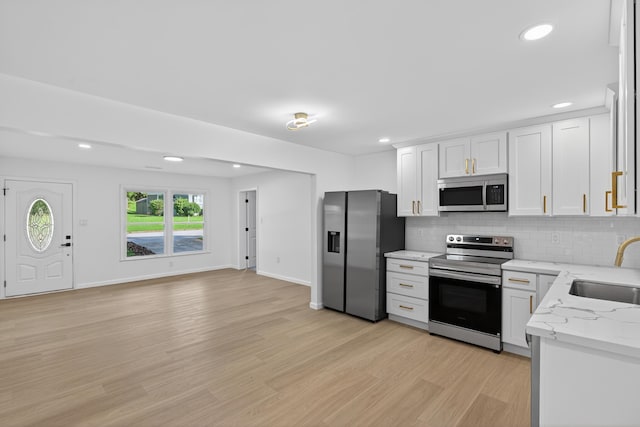 177 Lincoln Dr, Spartanburg, SC 29306 - kitchen with stainless steel appliances, decorative backsplash, light wood-style floors, recessed lighting, and white cabinets