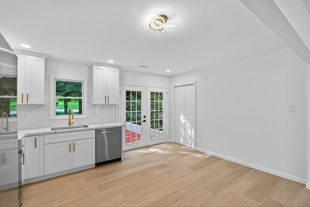 177 Lincoln Dr, Spartanburg, SC 29306 - kitchen with stainless steel dishwasher, light wood-type flooring, light countertops, french doors, and backsplash