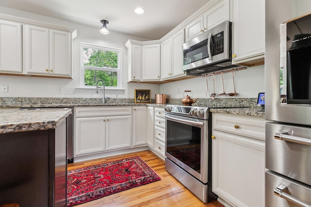 31 Goodwin Farms Ct, Travelers Rest, SC 29690 - kitchen featuring stainless steel appliances, light wood-type flooring, white cabinets, light stone countertops, and recessed lighting