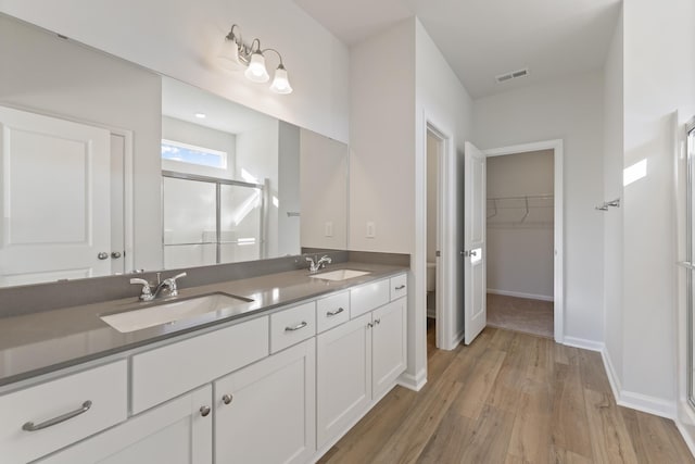1465 Macedonia Rd, Gaffney, SC 29341 - full bathroom featuring a shower stall, double vanity, wood finished floors, and a spacious closet
