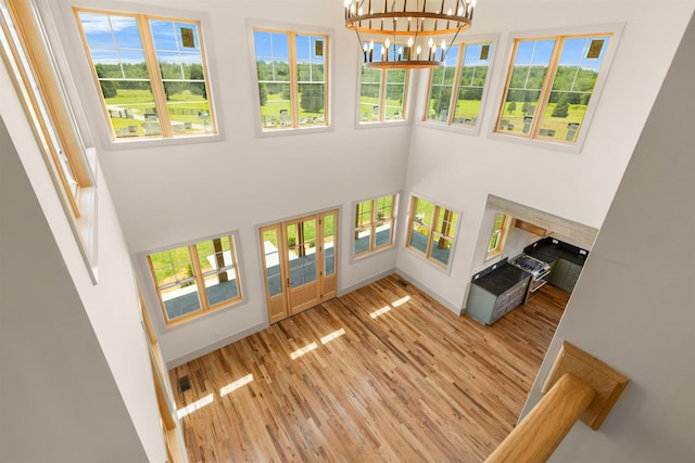 621 Bascule Ridge Ln, Campobello, SC 29322 - unfurnished living room with plenty of natural light, a towering ceiling, wood finished floors, and a chandelier
