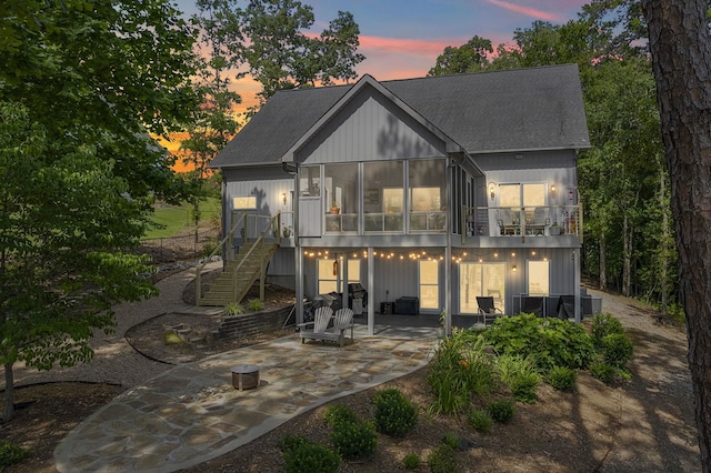 346 Bub Dr, Chesnee, SC 29323 - back of property at dusk with a patio, roof with shingles, stairway, and a sunroom
