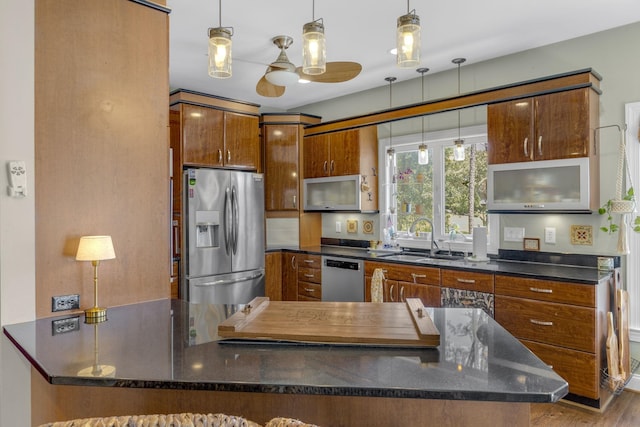 346 Bub Dr, Chesnee, SC 29323 - kitchen with appliances with stainless steel finishes, brown cabinets, ceiling fan, pendant lighting, and dark stone countertops