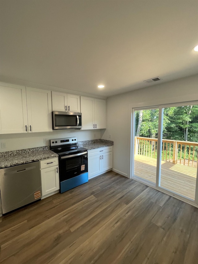 631 S Center St, Spartanburg, SC 29301 - kitchen featuring appliances with stainless steel finishes, white cabinetry, recessed lighting, light stone countertops, and dark wood-type flooring