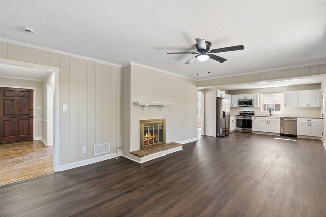 306 Fernwood Dr, Spartanburg, SC 29307 - unfurnished living room featuring dark wood-style floors, a ceiling fan, ornamental molding, and a brick fireplace