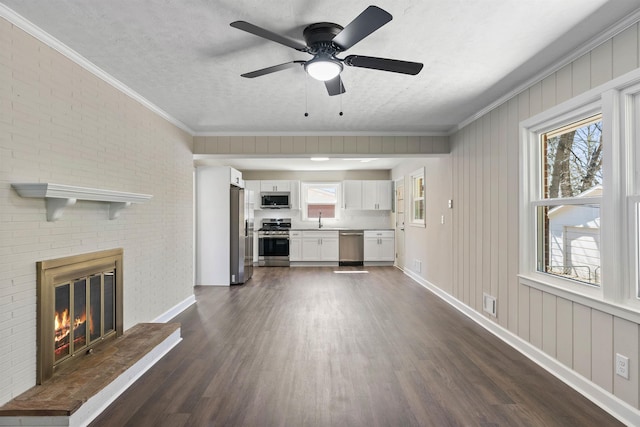 306 Fernwood Dr, Spartanburg, SC 29307 - unfurnished living room with dark wood-style flooring, plenty of natural light, ceiling fan, a brick fireplace, and ornamental molding