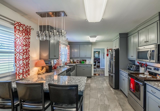 849 Harvey Rd, Greer, SC 29651 - kitchen with appliances with stainless steel finishes, light stone countertops, a peninsula, gray cabinets, and a breakfast bar area