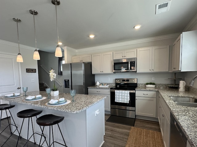 101 Deno Dr, Gaffney, SC 29341 - kitchen with stainless steel appliances, a kitchen island, dark wood-type flooring, a breakfast bar, and light stone counters