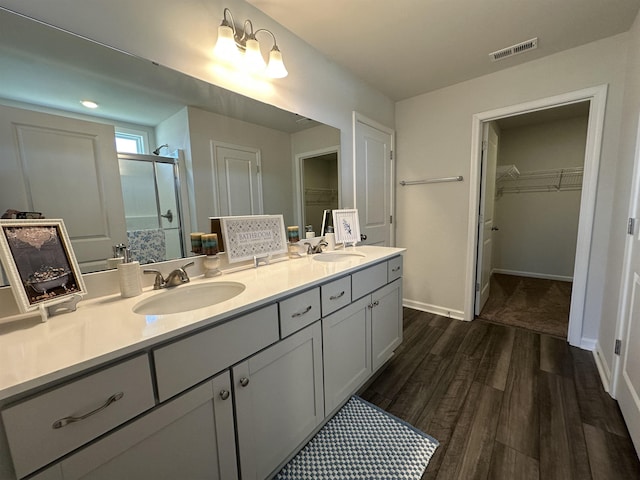 101 Deno Dr, Gaffney, SC 29341 - bathroom featuring a walk in closet, double vanity, a stall shower, and wood finished floors