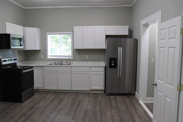 305 Spring St, Union, SC 29379 - kitchen featuring appliances with stainless steel finishes, white cabinets, ornamental molding, and dark wood finished floors