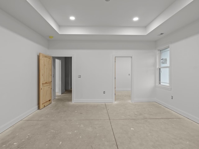 278 Forest Ave, Landrum, SC 29356 - unfurnished bedroom with a tray ceiling, concrete floors, a walk in closet, and recessed lighting