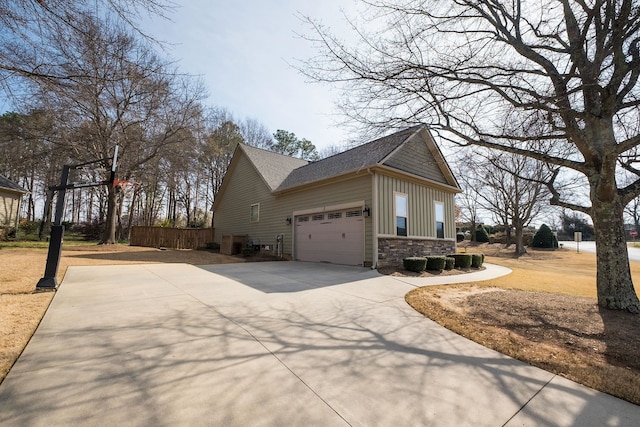 110 Coal Creek Dr, Boiling Springs, SC 29316 - view of side of property featuring board and batten siding, concrete driveway, stone siding, an attached garage, and roof with shingles