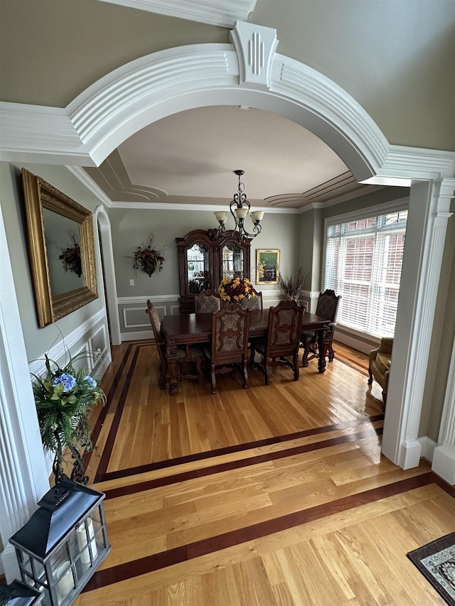 103 Welborn Oaks Way, Anderson, SC 29621 - dining space with arched walkways, a chandelier, wood finished floors, crown molding, and a wainscoted wall