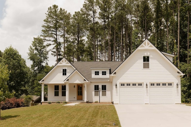 305 Meadow Tree Ct, Travelers Rest, SC 29690 - modern farmhouse style home with concrete driveway, a front lawn, a shingled roof, a garage, and view of wooded area