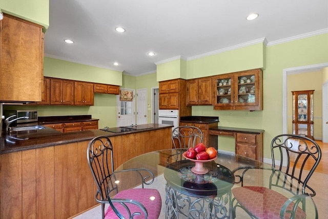 216 Antrim Ave, Moore, SC 29369 - kitchen featuring oven, a peninsula, dark countertops, recessed lighting, and brown cabinetry