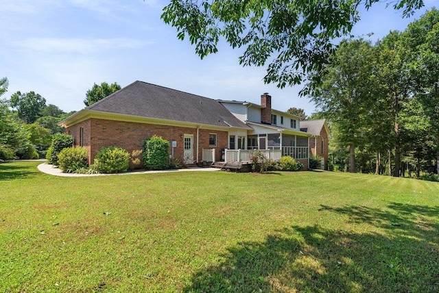 216 Antrim Ave, Moore, SC 29369 - rear view of property featuring a sunroom, brick siding, a lawn, and a chimney