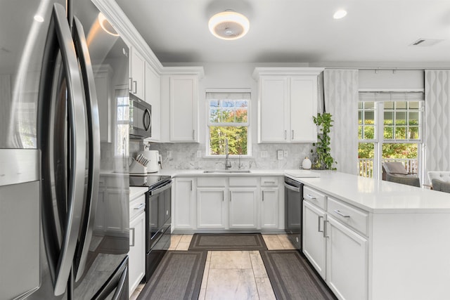 154 S Lake Emory Dr, Inman, SC 29349 - kitchen featuring black appliances, a peninsula, decorative backsplash, and healthy amount of natural light