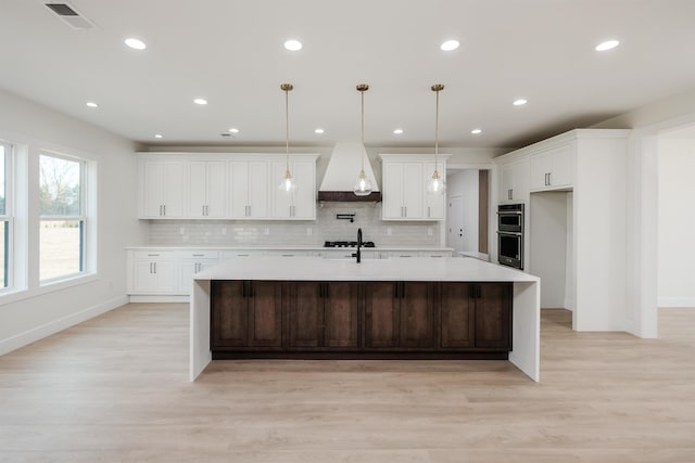 3619 Pennington Rd, Greer, SC 29651 - kitchen featuring custom exhaust hood, a spacious island, light countertops, light wood-style floors, and recessed lighting