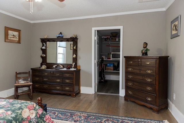 1218 Parker Rd, Enoree, SC 29335 - bedroom featuring wood finished floors, a walk in closet, crown molding, a textured ceiling, and ceiling fan