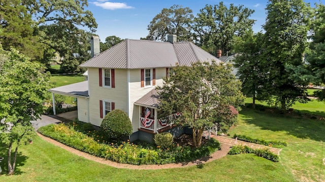 601 Front St, Chesnee, SC 29523 - view of home's exterior with a chimney, a yard, a carport, a metal roof, and covered porch