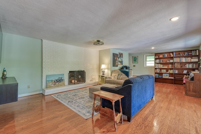 1212 Riveroak Rd, Inman, SC 29349 - living room with a textured ceiling, light wood-style floors, and a fireplace