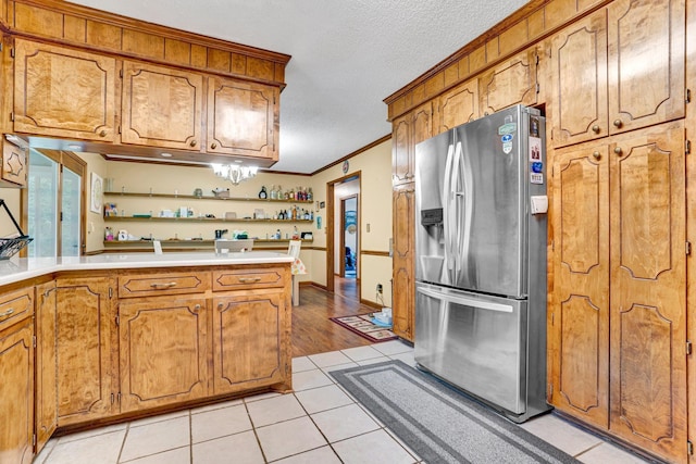 590 Hickory Nut Rd, Inman, SC 29349 - kitchen with stainless steel fridge, open shelves, brown cabinetry, a textured ceiling, and ornamental molding