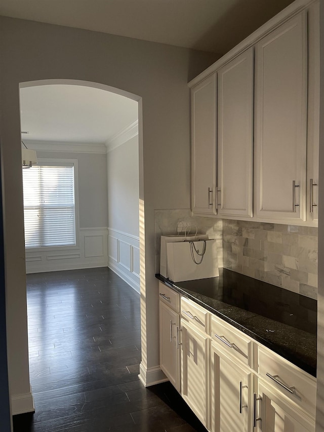 499 Gorham Dr, Boiling Springs, SC 29316 - kitchen featuring crown molding, arched walkways, a wainscoted wall, dark wood-type flooring, and a decorative wall