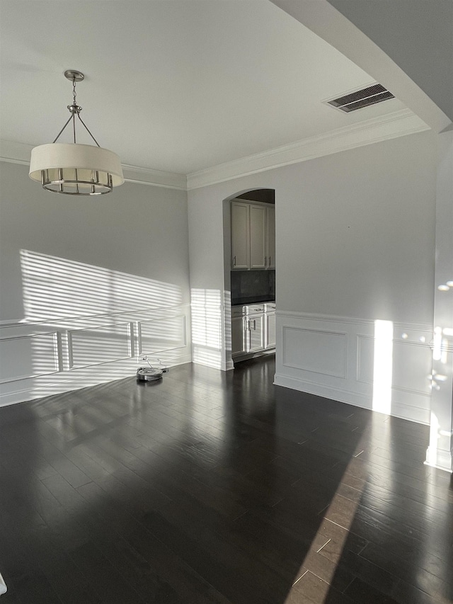 499 Gorham Dr, Boiling Springs, SC 29316 - unfurnished living room with crown molding, dark wood-type flooring, arched walkways, wainscoting, and a decorative wall