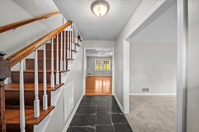 251 Winfield Dr, Spartanburg, SC 29307 - entryway featuring a textured ceiling, stairway, dark carpet, and dark stone finish floors