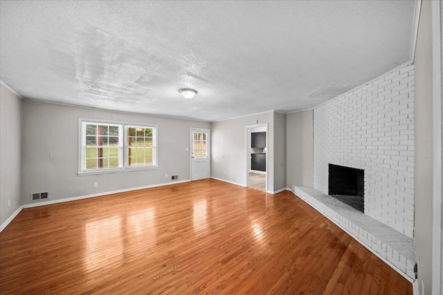 251 Winfield Dr, Spartanburg, SC 29307 - unfurnished living room featuring a textured ceiling, a brick fireplace, and wood finished floors