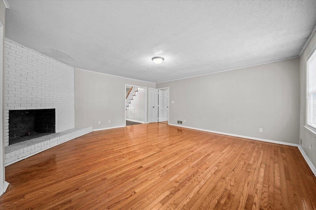 251 Winfield Dr, Spartanburg, SC 29307 - unfurnished living room featuring wood finished floors, a textured ceiling, stairs, and a fireplace