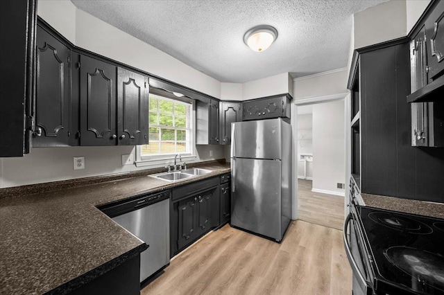 251 Winfield Dr, Spartanburg, SC 29307 - kitchen featuring appliances with stainless steel finishes, dark countertops, a textured ceiling, light wood-style flooring, and dark cabinets