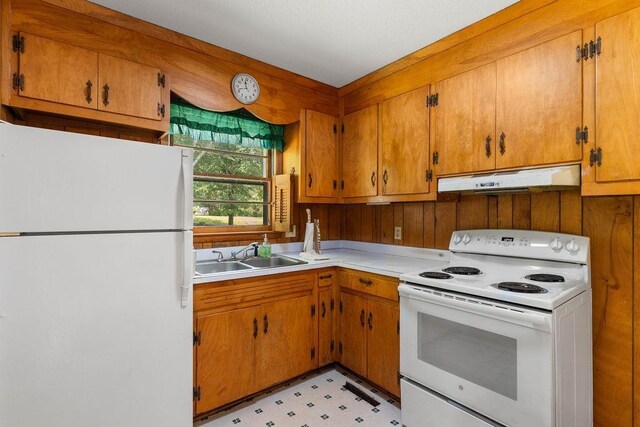 210 Catawba St, Union, SC 29379 - kitchen with white appliances, under cabinet range hood, brown cabinets, and light countertops