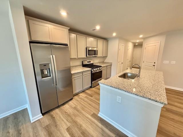 1236 Forestbrook Ln, Spartanburg, SC 29303 - kitchen with appliances with stainless steel finishes, light wood finished floors, a center island with sink, light stone countertops, and recessed lighting