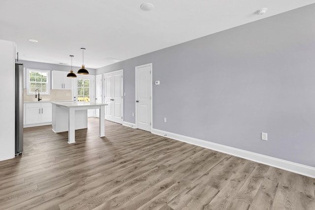 938 Logan St, Spartanburg, SC 29306 - kitchen featuring a breakfast bar area, light wood-style flooring, white cabinetry, light countertops, and a kitchen island