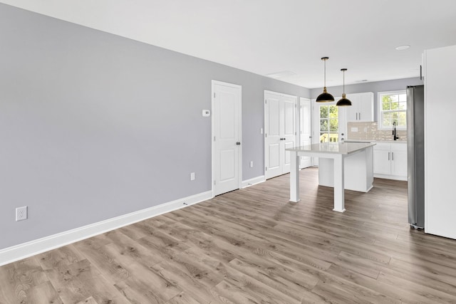 938 Logan St, Spartanburg, SC 29306 - kitchen featuring a breakfast bar area, a kitchen island, white cabinets, light countertops, and tasteful backsplash