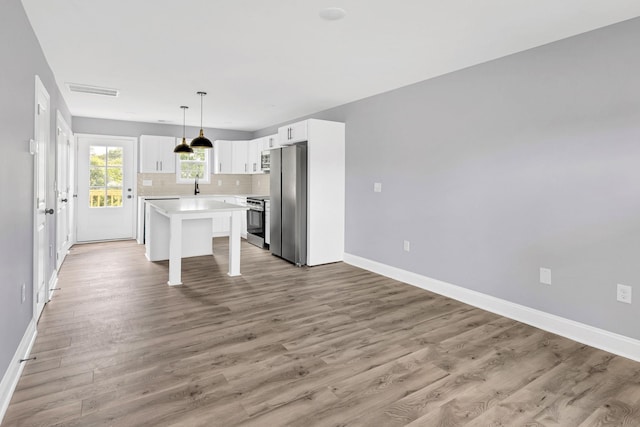 938 Logan St, Spartanburg, SC 29306 - kitchen with appliances with stainless steel finishes, light countertops, light wood finished floors, and white cabinetry