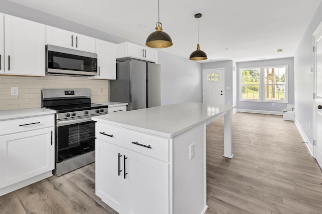 938 Logan St, Spartanburg, SC 29306 - kitchen featuring stainless steel appliances, light wood-style flooring, backsplash, light countertops, and a kitchen island