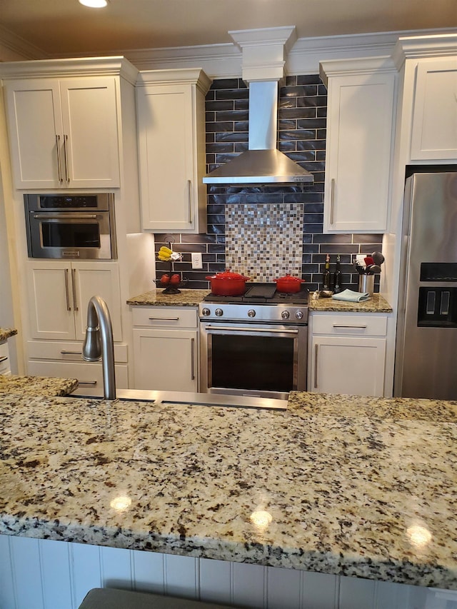 178 Ravines Ln, Spartanburg, SC 29301 - kitchen featuring stainless steel appliances, exhaust hood, light stone counters, white cabinetry, and ornamental molding