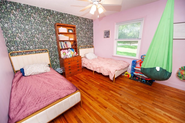 72 Casey Ln, Spartanburg, SC 29301 - bedroom with wallpapered walls, wood finished floors, a ceiling fan, and an accent wall