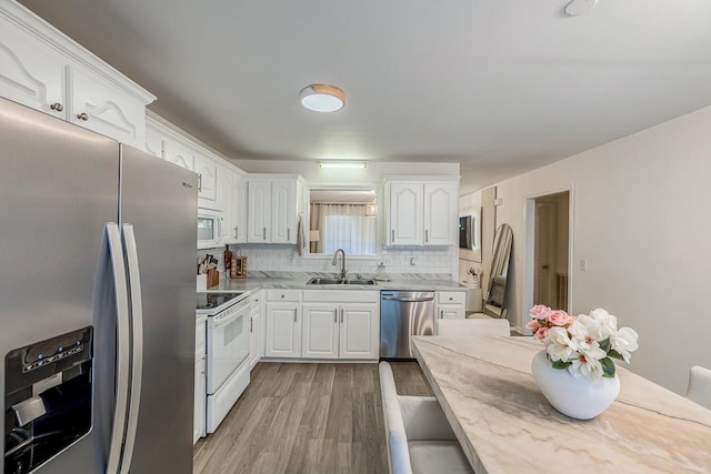 521 Signal Hill Ln, Inman, SC 29349 - kitchen with stainless steel appliances, light wood-style flooring, tasteful backsplash, and white cabinets