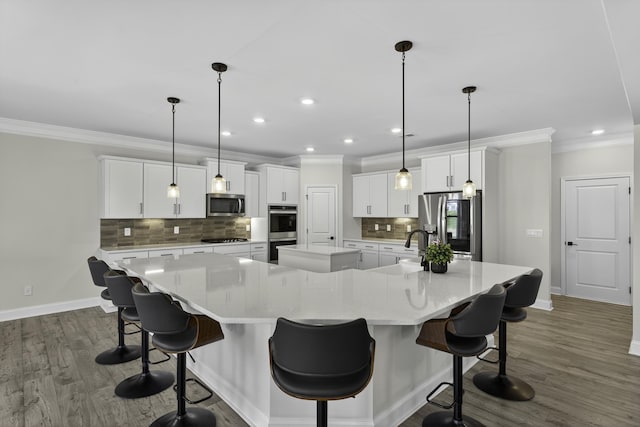 3027 Toliver, Boiling Springs, SC 29316 - kitchen featuring appliances with stainless steel finishes, a large island, ornamental molding, tasteful backsplash, and white cabinets