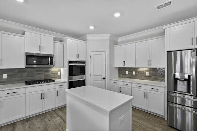 3027 Toliver, Boiling Springs, SC 29316 - kitchen featuring stainless steel appliances, crown molding, white cabinets, wood finished floors, and backsplash