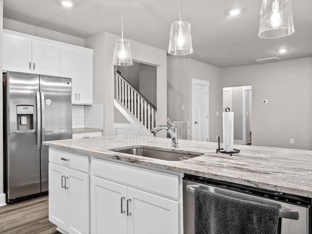 1116 Denington Dr, Spartanburg, SC 29307 - kitchen featuring appliances with stainless steel finishes, light stone counters, white cabinetry, pendant lighting, and wood finished floors