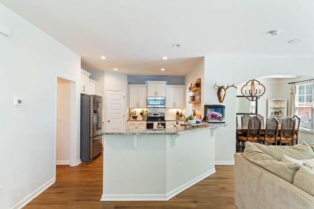 222 Eventine Way, Boiling Springs, SC 29316 - kitchen featuring appliances with stainless steel finishes, a peninsula, a breakfast bar area, a chandelier, and dark wood-style floors