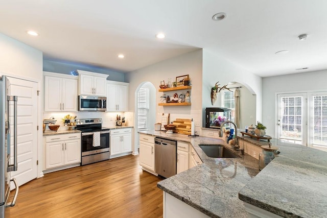 222 Eventine Way, Boiling Springs, SC 29316 - kitchen featuring stainless steel appliances, arched walkways, open shelves, decorative backsplash, and white cabinets