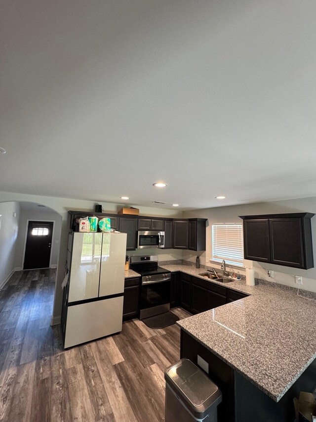 711 Burbrook Ln, Boiling Springs, SC 29316 - kitchen featuring stainless steel appliances, a peninsula, dark wood finished floors, a kitchen bar, and arched walkways