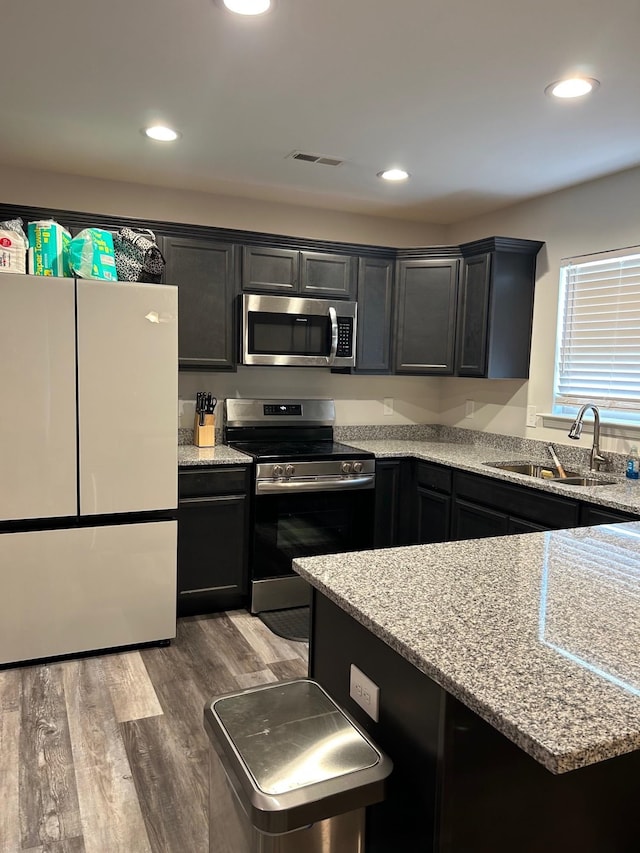 711 Burbrook Ln, Boiling Springs, SC 29316 - kitchen with stainless steel appliances, wood finished floors, recessed lighting, light stone countertops, and dark cabinetry