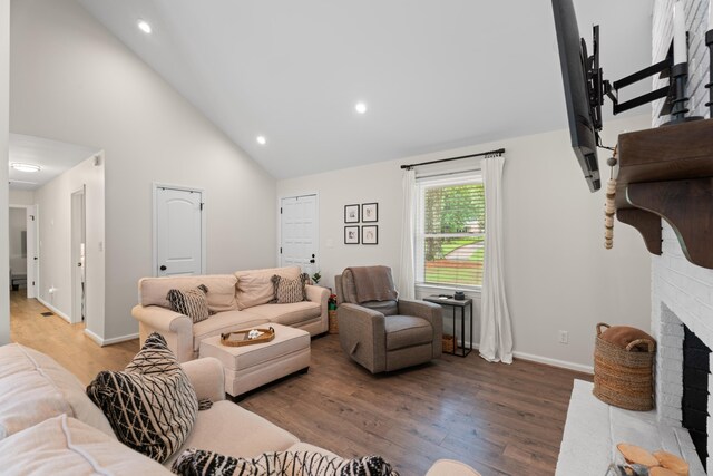 15864 Asheville Hwy, Campobello, SC 29322 - living area featuring a brick fireplace, wood finished floors, high vaulted ceiling, and recessed lighting