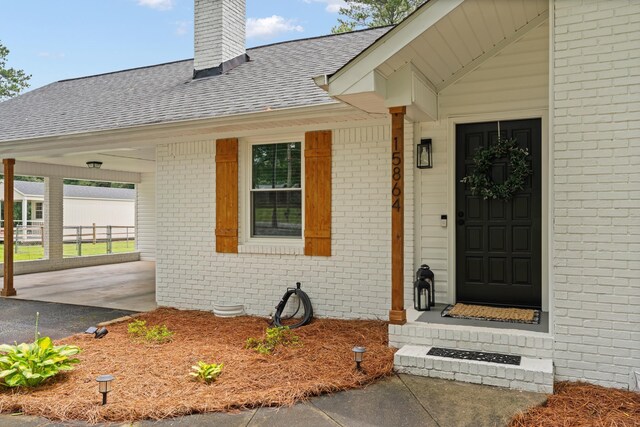15864 Asheville Hwy, Campobello, SC 29322 - doorway to property featuring brick siding, a chimney, a shingled roof, and a carport